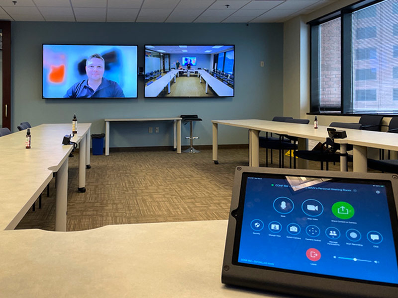 A LG display with a QSYS camera and Klipsch speakers for a conference room